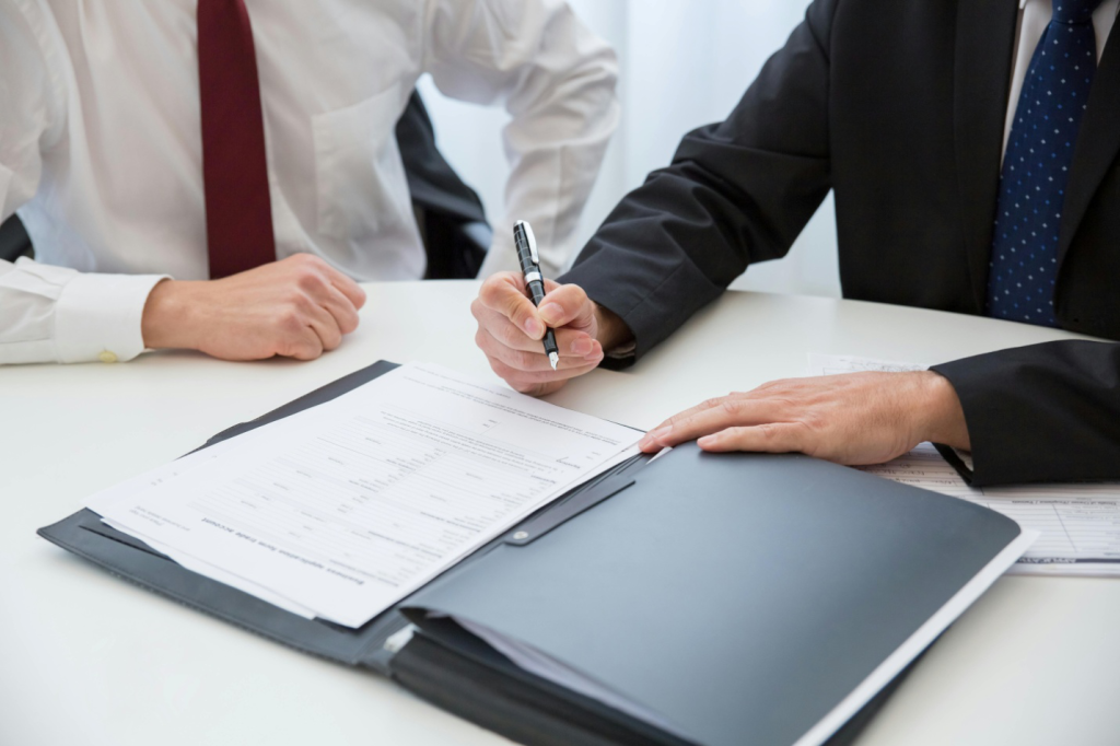 A picture of a person signing a document
