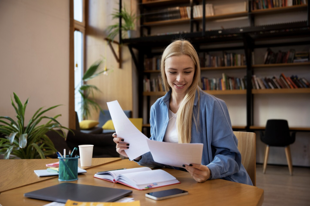 An Australian woman carefully reviewing documents for a job application in France.