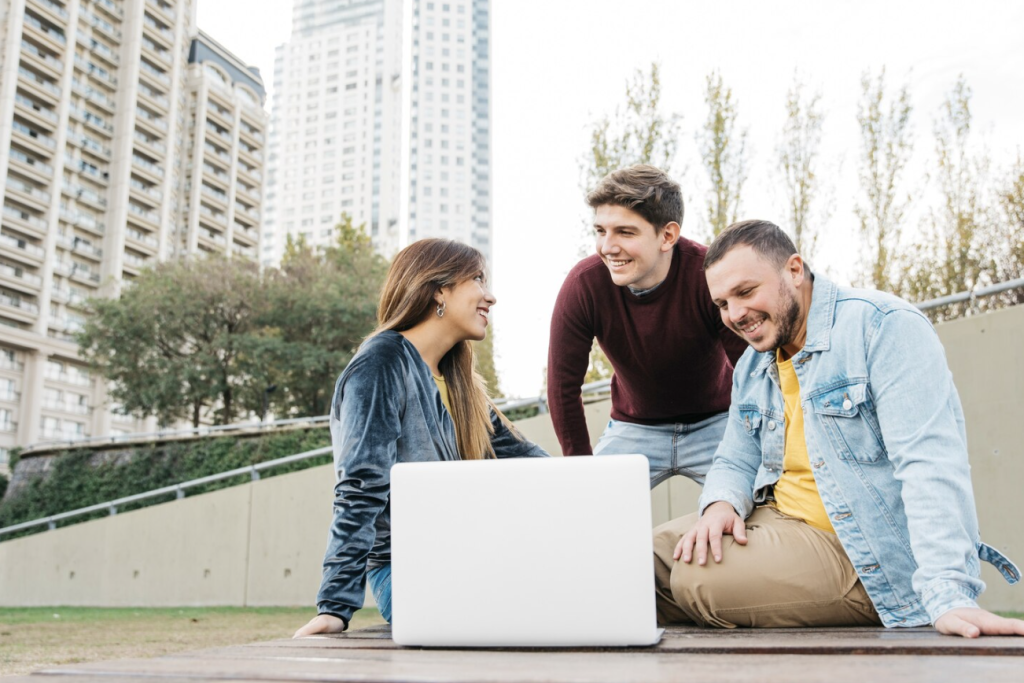 A group of friends exploring job opportunities on a laptop.